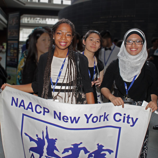 3 Midwood students holding an NAACP New York banner