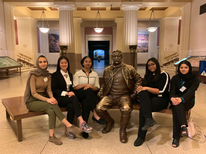 Group photo of the finalists next to a statue of Theodore Roosevelt